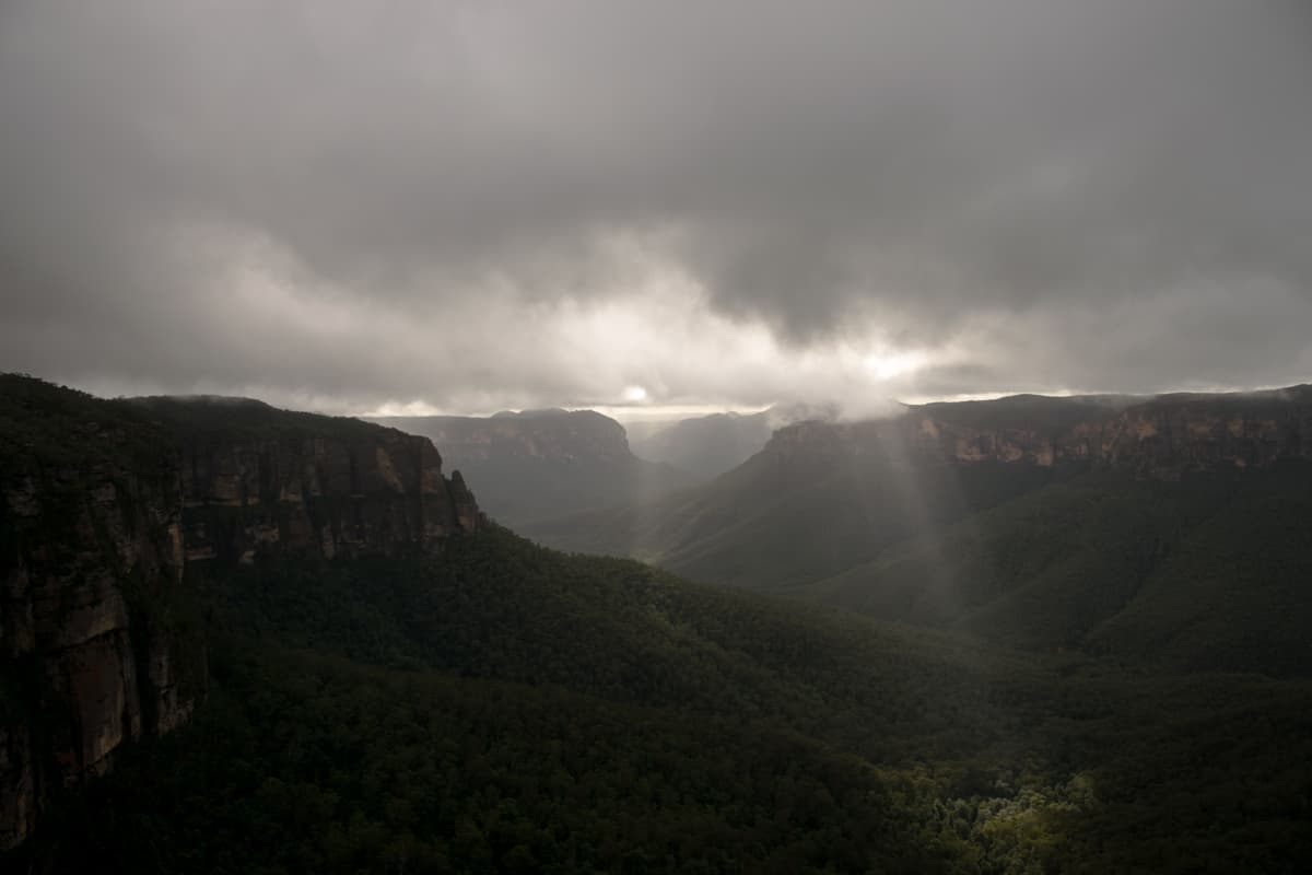 Light breaking over forested ranges in the Blue Mountains.